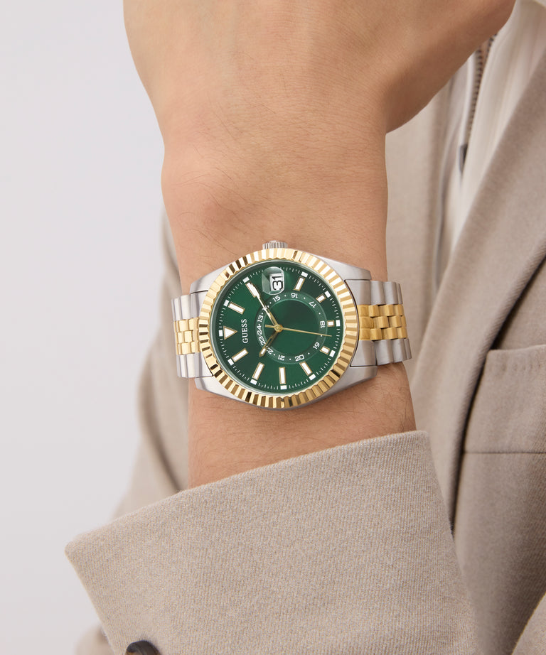Gold and silver watch with green face on a wrist against a neutral background GW0977G4