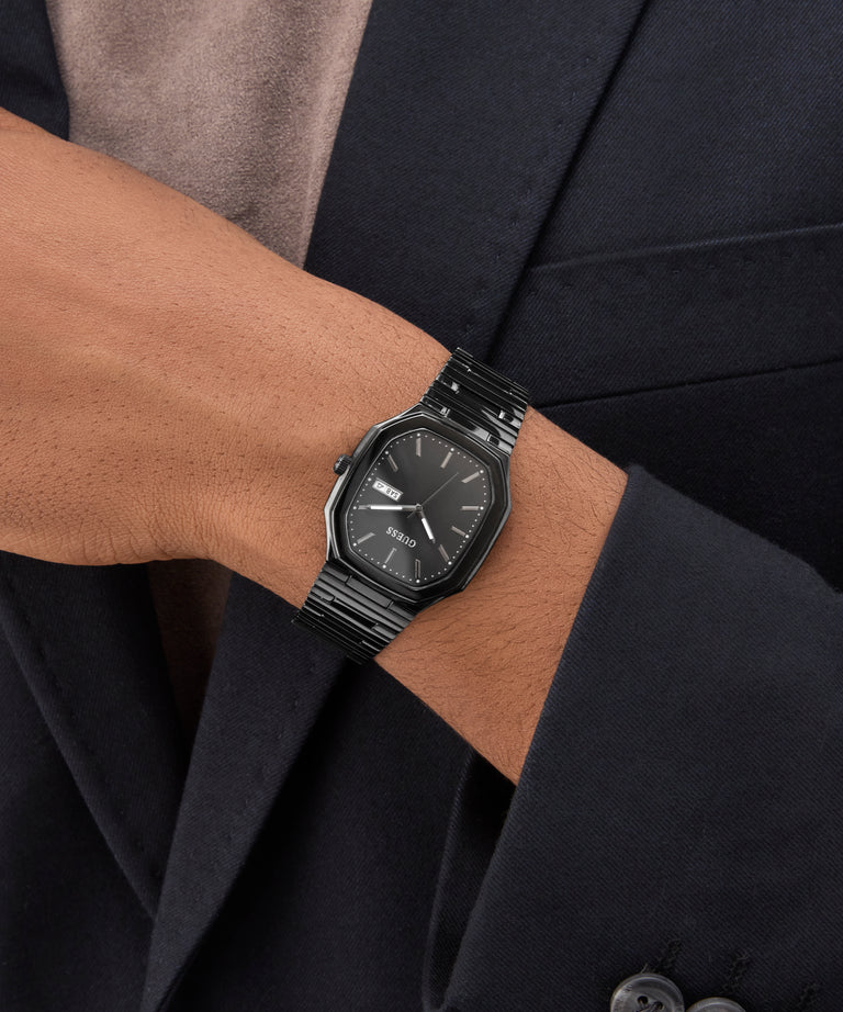 GUESS Mens Black Date Watch on a wrist with a dark suit background
