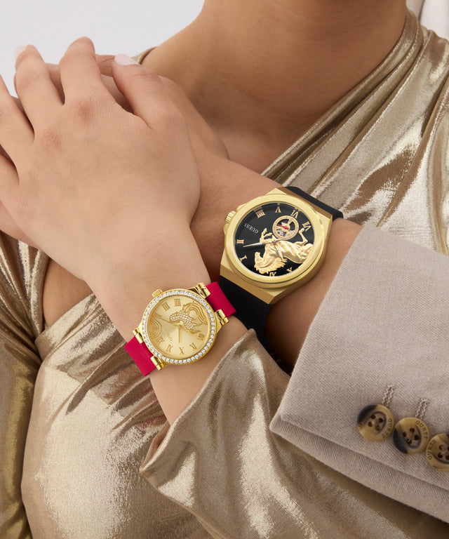 Two gold GUESS Mens Limited Edition Lunar New Year Black Gold Tone Analog Watches on a person's wrist with a neutral background