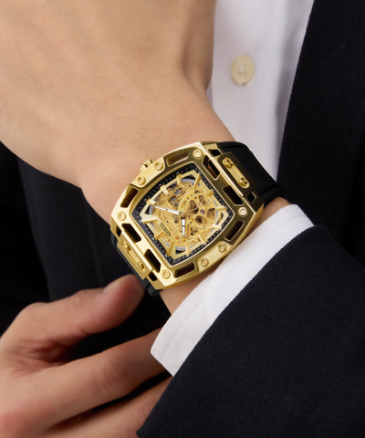 GUESS Mens Black Gold Tone Automatic Watch with black strap on a person wearing a suit