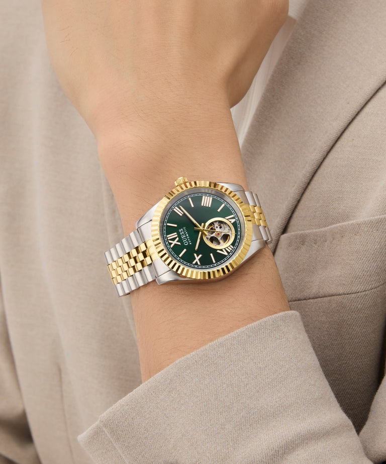 GUESS Mens 2-Tone Automatic Watch on a wrist with a neutral background