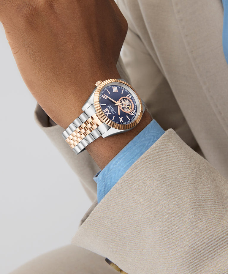 GUESS Mens 2-Tone Automatic Watch on a person's wrist with a neutral background