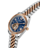 Two-tone Guess watch with blue dial and rose gold accents on a white background lifestyle