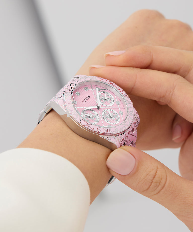 GUESS Ladies Pink Multi-function Watch with silver accents on a wrist against a light background