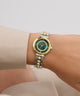 Gold and silver GUESS Ladies 2-Tone Analog Watch on a wrist with a plain background