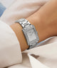 Silver GUESS Ladies Silver Tone Analog Watch with diamond accents on a wrist against a light background
