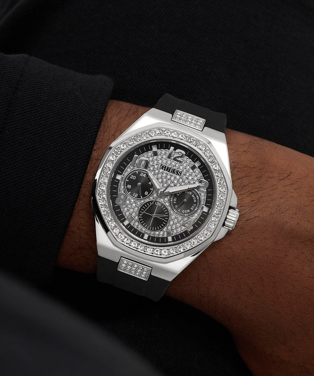 GUESS Mens Black Silver Tone Analog Watch with diamond-studded face on a wrist against a dark background