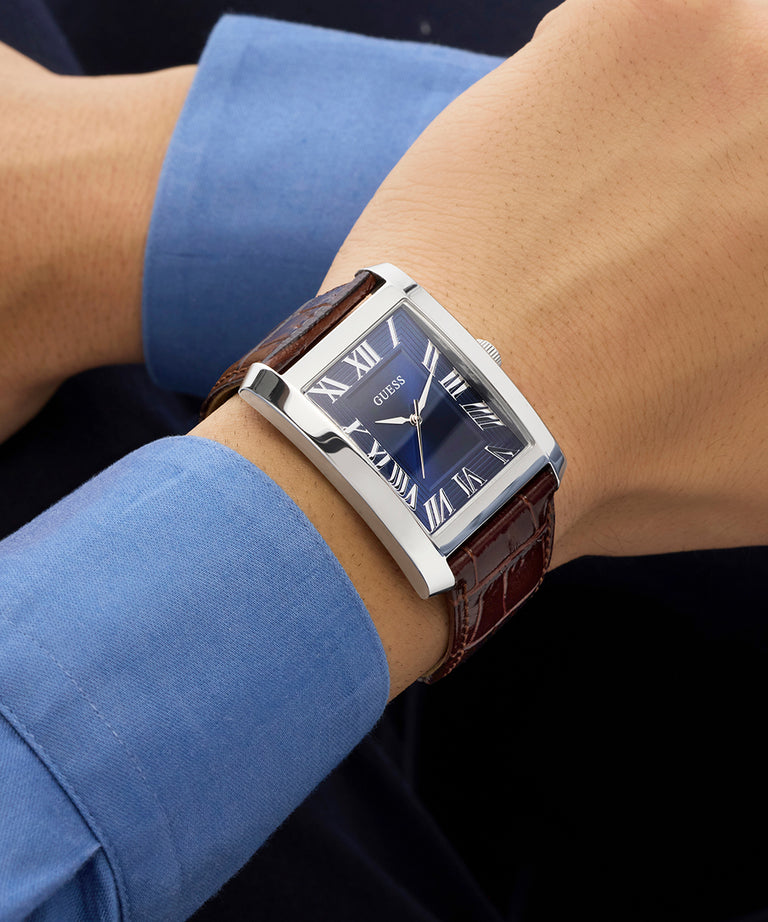 GUESS Mens BROWN SILVER TONE Analog Watch on a wrist with a blue shirt sleeve