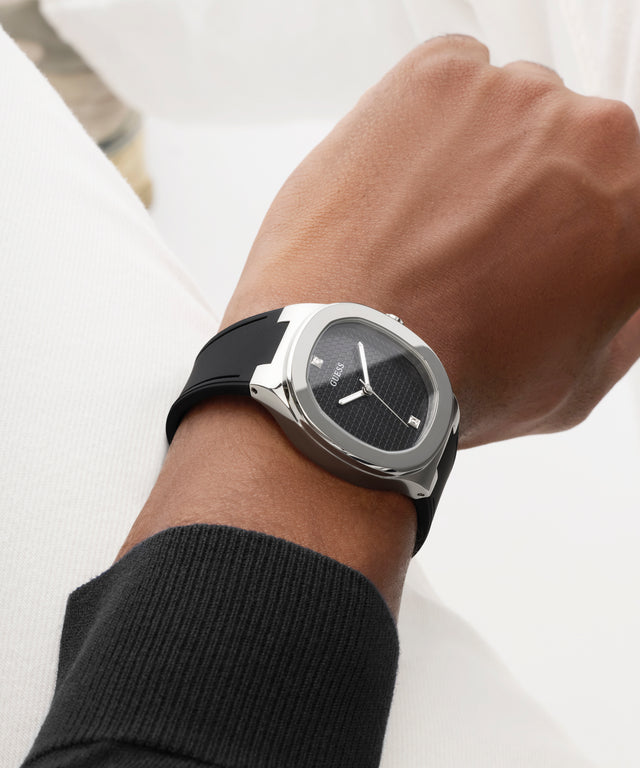 Close-up of a wrist wearing a black watch with a white background