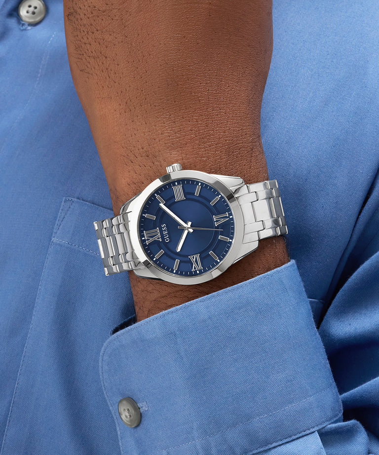 GUESS Mens SILVER TONE Analog Watch with blue dial on a wrist, wearing a blue shirt.