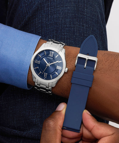 Person wearing a blue and silver GUESS Mens SILVER TONE Analog Watch with a matching strap