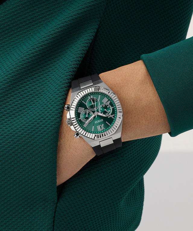 Green GUESS Mens Equity Black Silver Tone Analog Watch on a person's wrist with a green sweater
