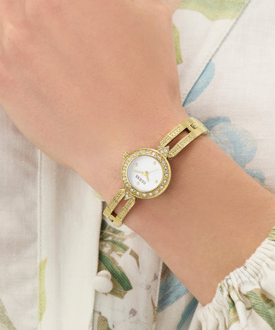 GUESS Ladies Gold Tone Analog Watch on a wrist with a floral-patterned garment