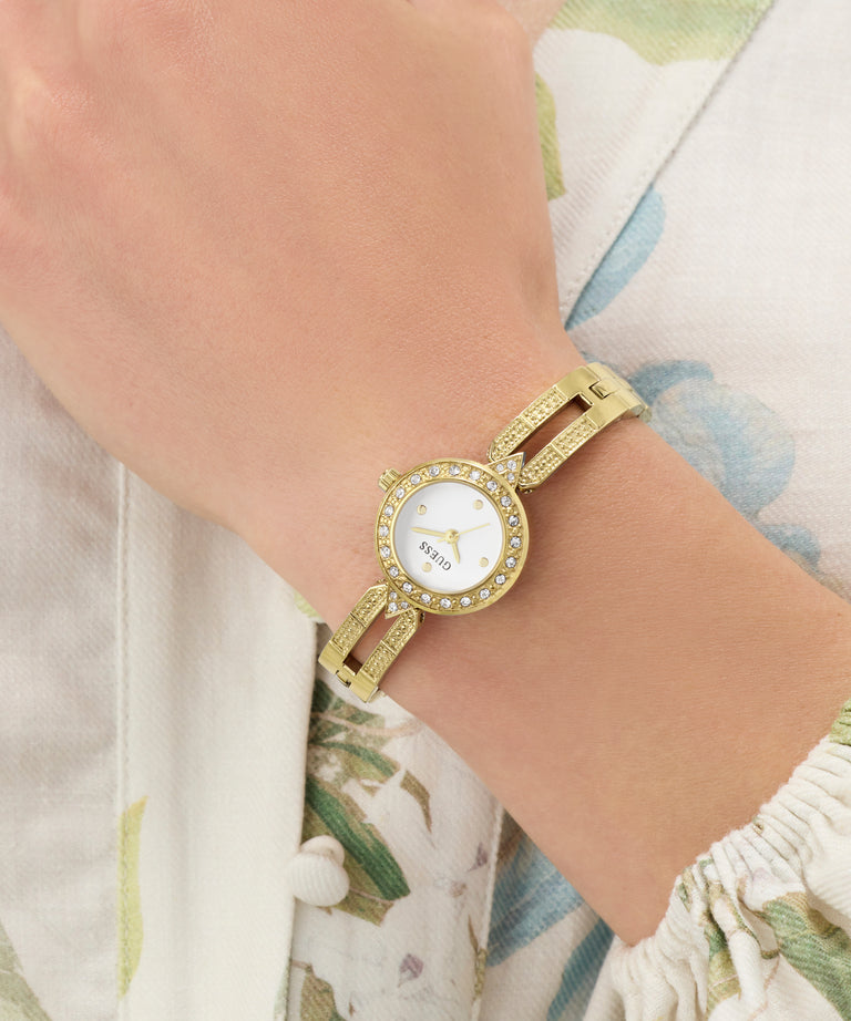 GUESS Ladies Gold Tone Analog Watch on a wrist with a floral-patterned garment