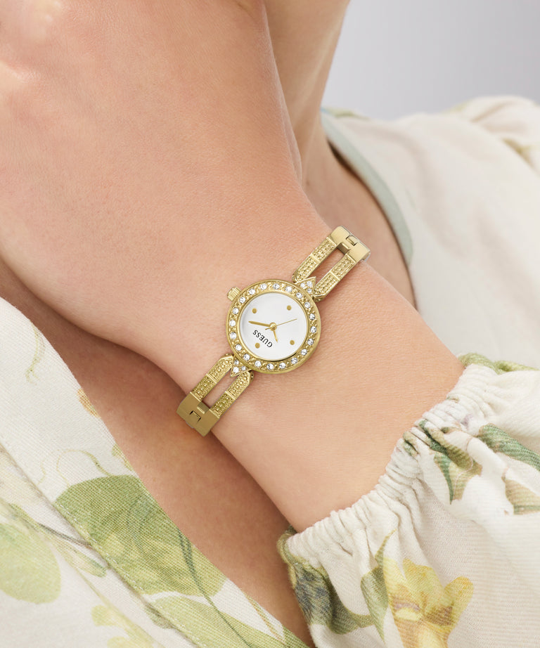GUESS Ladies Gold Tone Analog Watch on a wrist with a floral-patterned garment