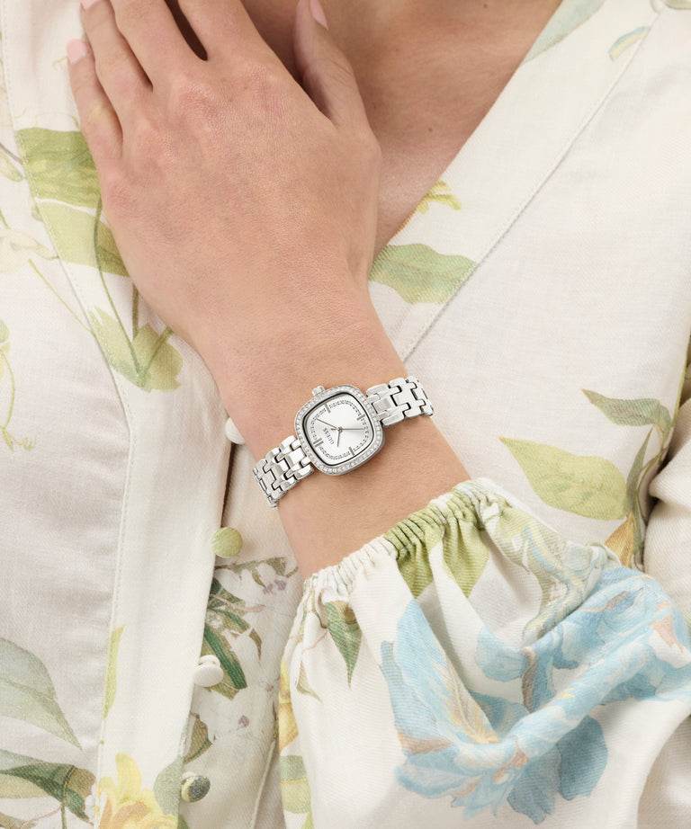GUESS Ladies Hazel Silver Tone Analog Watch on a wrist with a floral-patterned garment