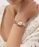 Rose Gold watch on a wrist with a white lace garment