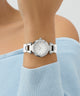Silver watch on a wrist with a light blue sweater