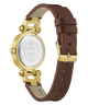 The back view of a GUESS wristwatch with a brown leather strap and gold-tone case, showing the stainless steel case back and buckle.