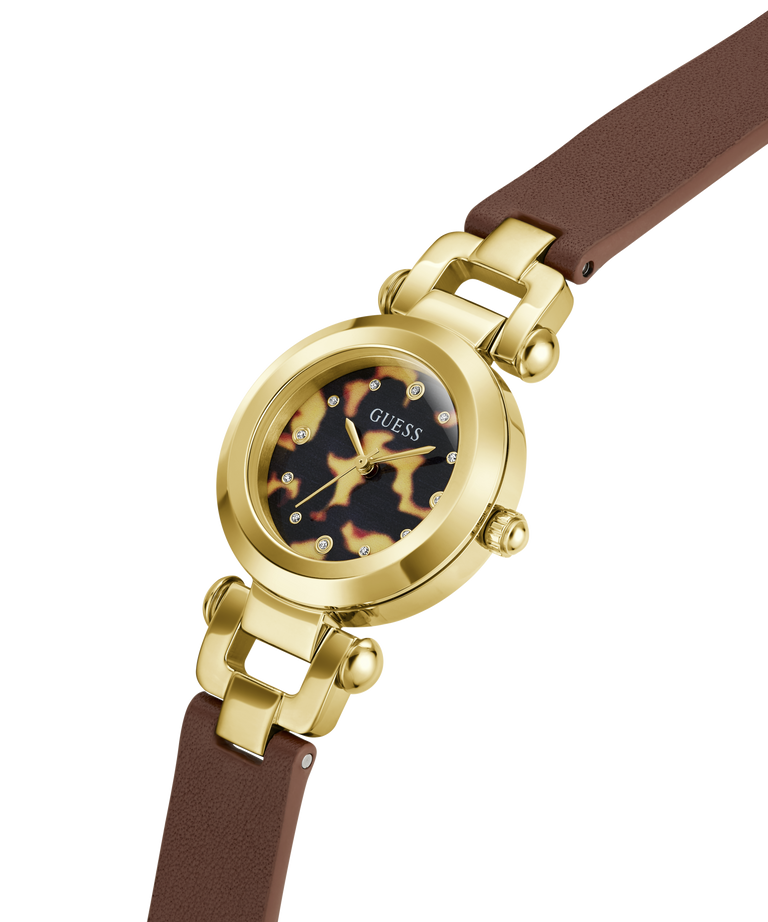 A GUESS women's watch featuring a gold-tone round case, a tortoiseshell-patterned dial with crystal hour markers, and a brown leather strap, shown on a solid white background. lifestyle