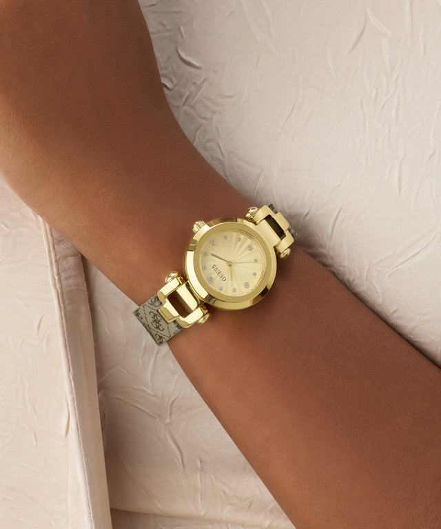 Gold watch on a wrist with a neutral background