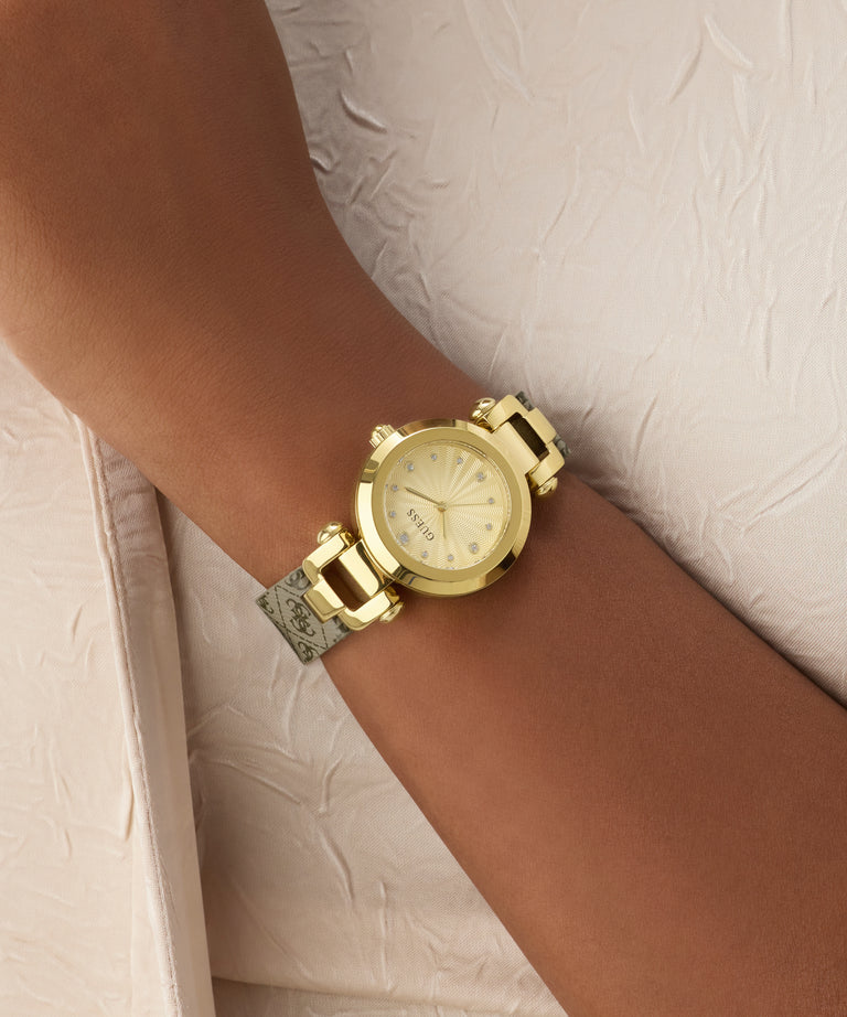 Gold watch on a wrist with a neutral background