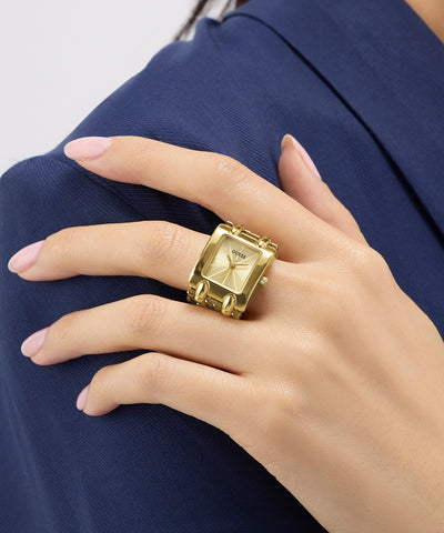 GUESS Ladies Mod Heavy Metal Gold Tone Analog Watch Ring with watch face design on a hand against a blue background