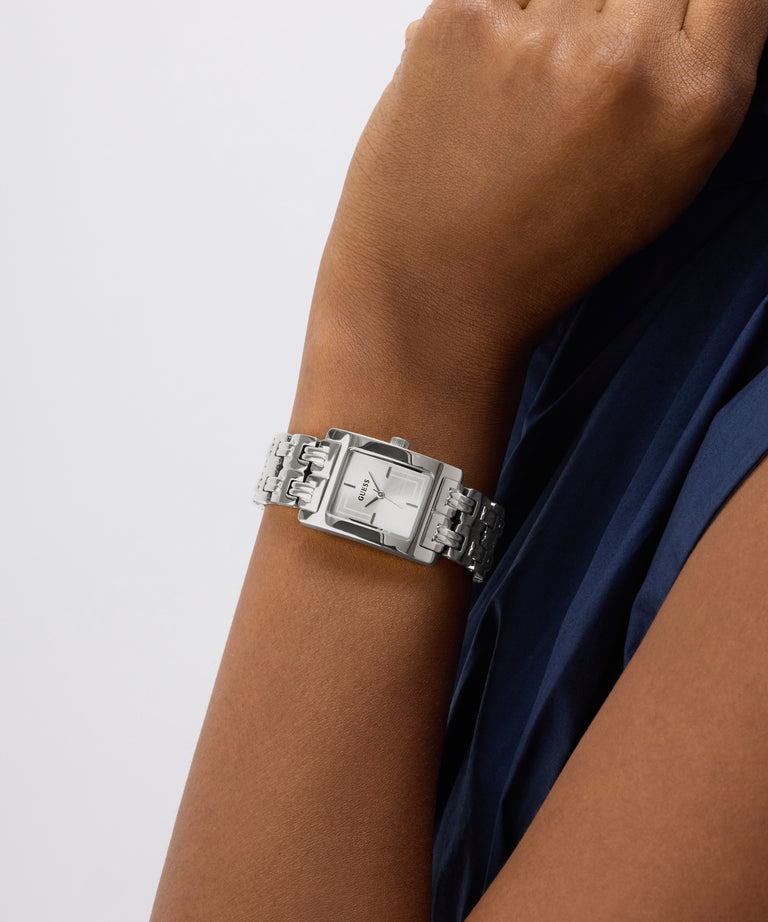 Silver GUESS Ladies Silver Tone Analog Watch on a wrist with a plain background