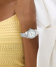 Silver Colette watch on a wrist with a yellow top and white background
