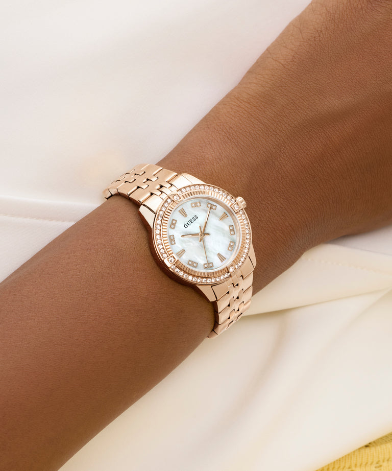 GUESS Ladies Colette Rose Gold Tone Analog Watch with diamond accents on a wrist against a white background