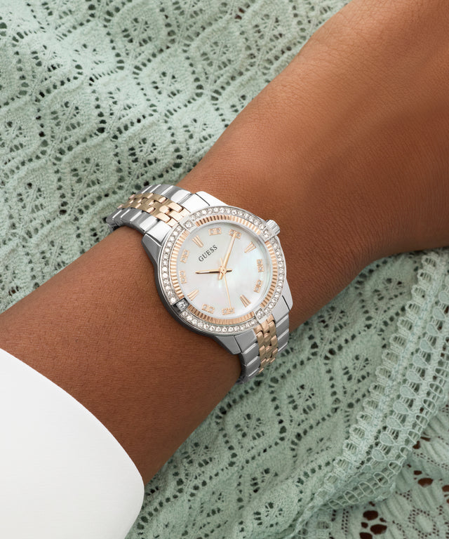 Silver and rose gold watch on a wrist with a lace background