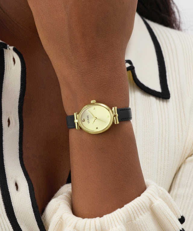 Gold watch on a wrist with a neutral background
