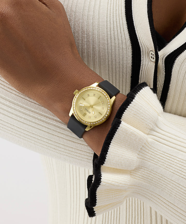 Gold watch on a wrist with a neutral background