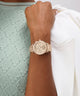 Gold watch on a wrist with a blurred background