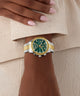 Gold and silver GUESS Ladies Birdie 2-Tone Analog Watch on a wrist with a neutral background