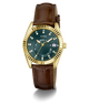 A GUESS wristwatch with a gold-tone case, a dark green dial, and a brown leather strap, shown on a clean white background.