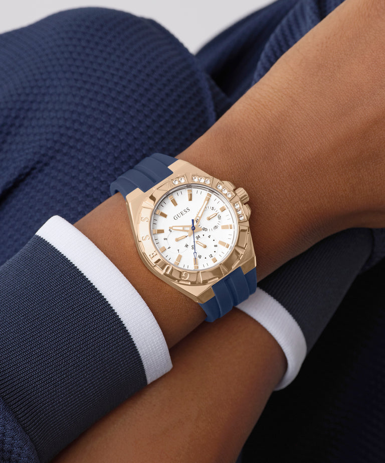 Gold watch with a blue strap on a wrist against a dark background