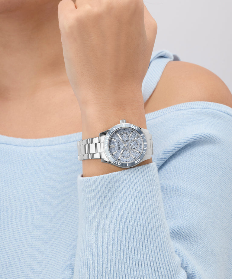 Silver GUESS Ladies Silver Tone Analog Watch on a wrist with a light blue sweater