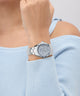 Silver GUESS Ladies Silver Tone Analog Watch on a wrist with a light blue sweater