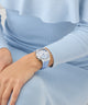 Person wearing a light blue GUESS Ladies Ice Blue Silver Tone Analog Watch with Swarovski ReCreated™ crystals on a matching light blue sweater