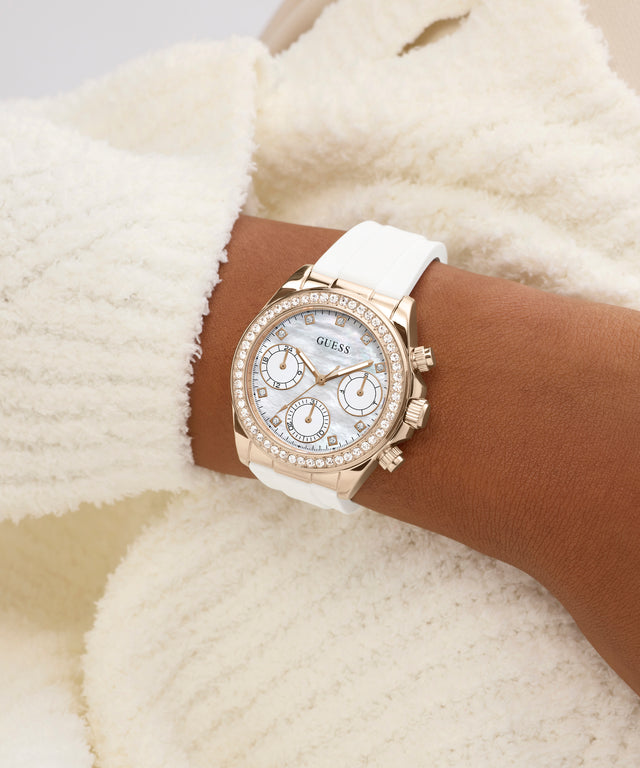 Luxury watch with white strap on a wrist against a soft, neutral background