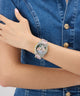 Person wearing a decorative GUESS Ladies Blue Analog Watch on a blue denim background