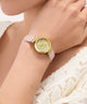 GUESS Ladies Light Pink Gold Tone Analog Watch watch with pink strap worn by a person in a white lace garment
