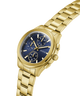 Gold GUESS Mens Palmer Gold Tone Analog Watch with a blue face on a white background lifestyle