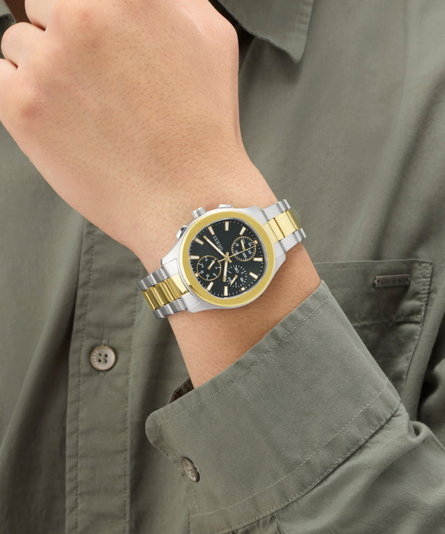 Gold and silver watch on a wrist with a green shirt
