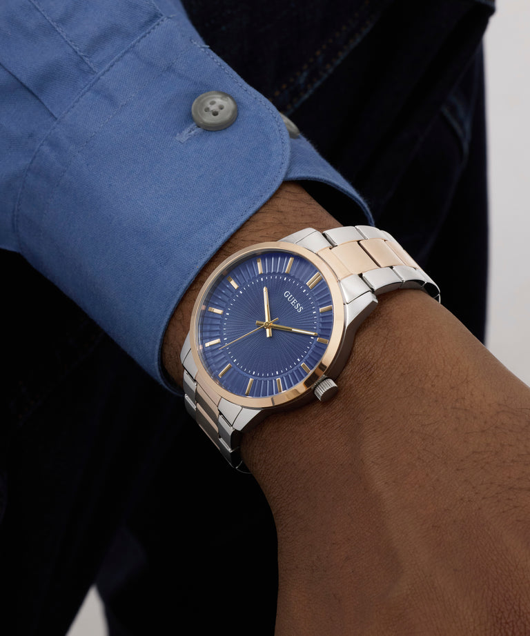 Silver and blue watch on a wrist with a blue shirt cuff.