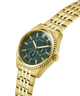 Gold watch with a green face on a white background lifestyle