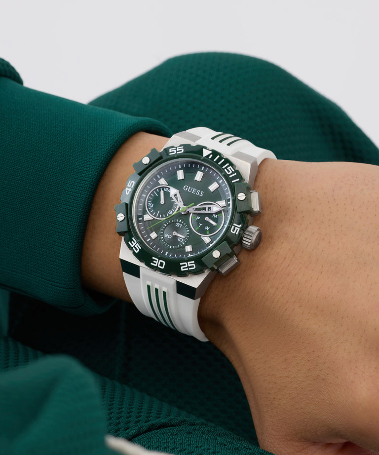 Person wearing a Guess watch on a wrist with a green sleeve.
