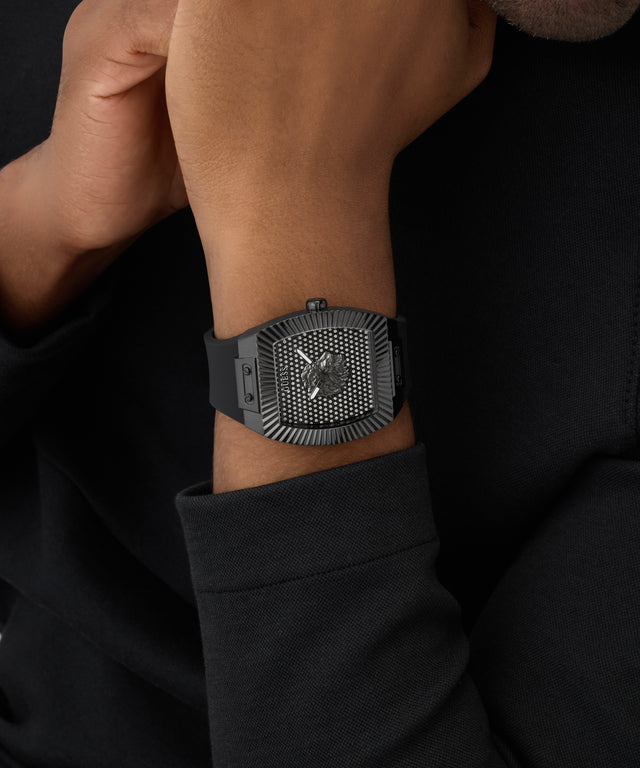 Black GUESS Mens Black Analog Watch on a person's wrist with a dark background