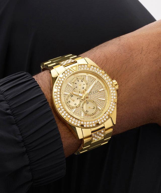 Gold watch with diamond accents on a wrist against a black background